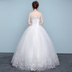 White wedding dress with floral details on a plain background