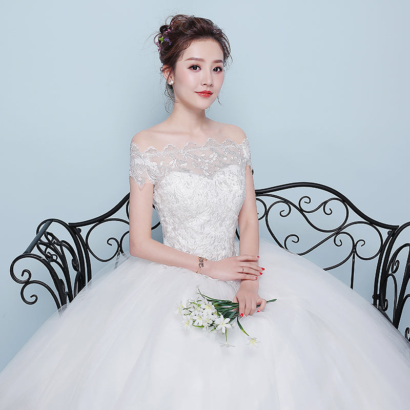 Woman in a white wedding dress holding flowers against a light blue background