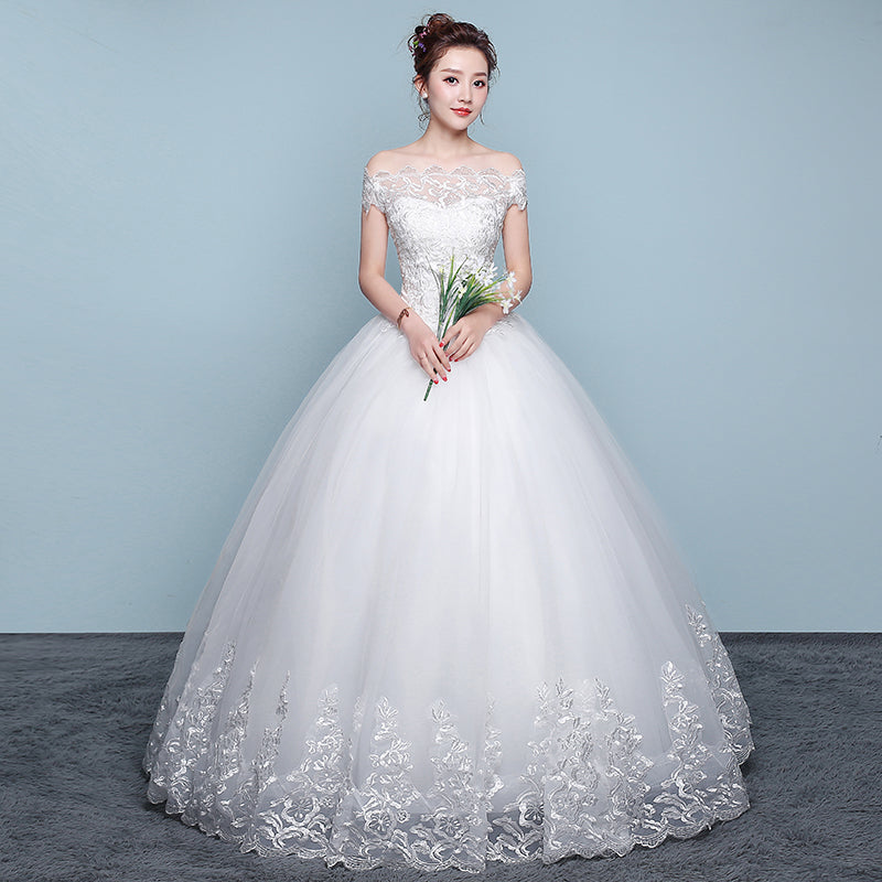 Woman in a white wedding dress holding flowers against a light blue background