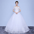 White wedding dress with floral details on a plain background