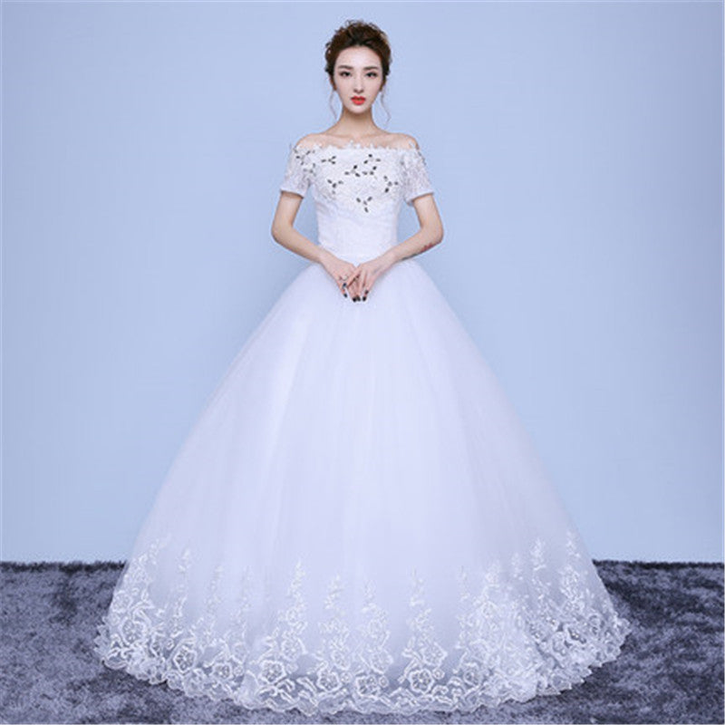 White wedding dress with floral details on a plain background
