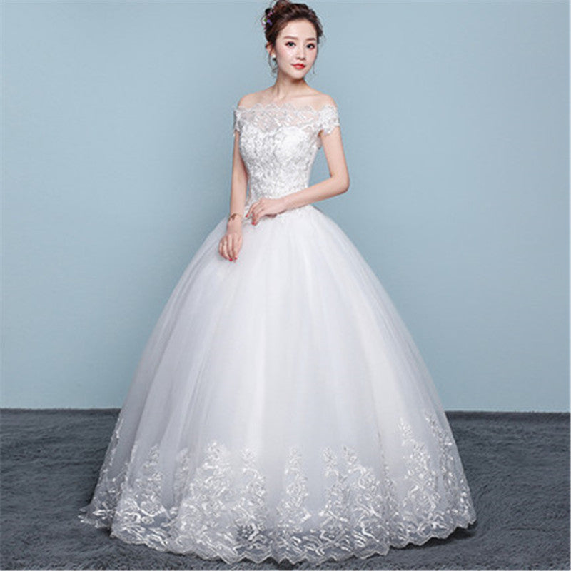 White wedding dress with lace details on a plain background