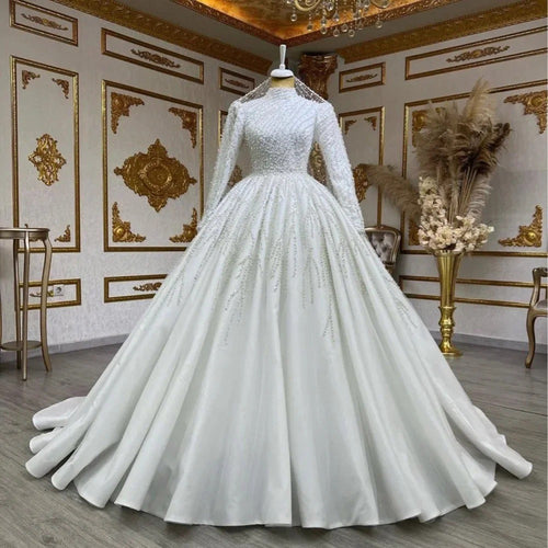 White wedding dress on a mannequin in an ornate room with gold accents.