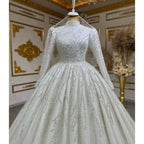Elegant silver beaded gown on a mannequin against an ornate wall.