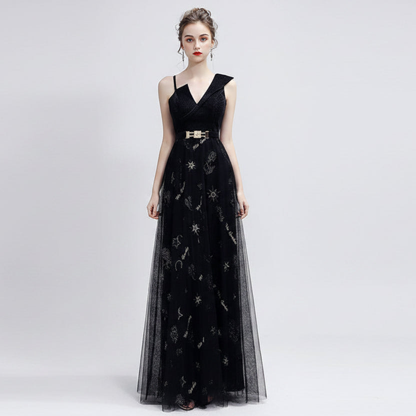 Woman wearing a black evening gown with silver embroidery on a white background