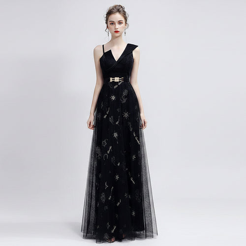 Woman wearing a black evening gown with silver embroidery on a white background