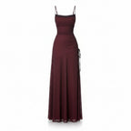 Burgundy evening gown with a slit on a white background