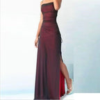 Burgundy strapless gown with a high slit on a light blue background