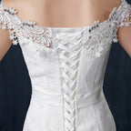 White lace dress with intricate detailing on a dark background