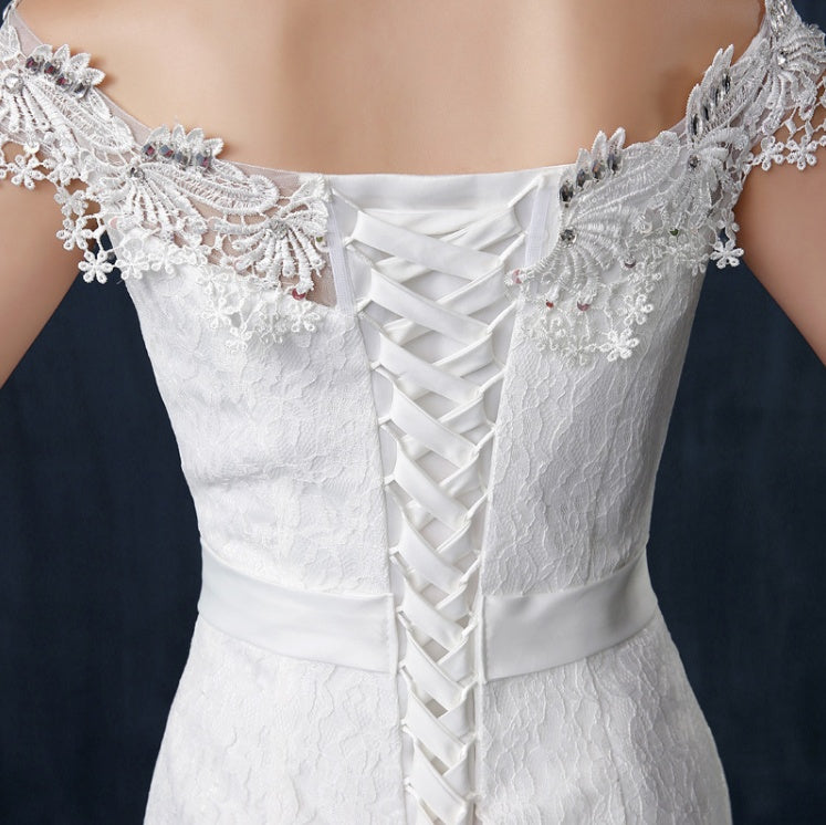 White lace dress with intricate detailing on a dark background
