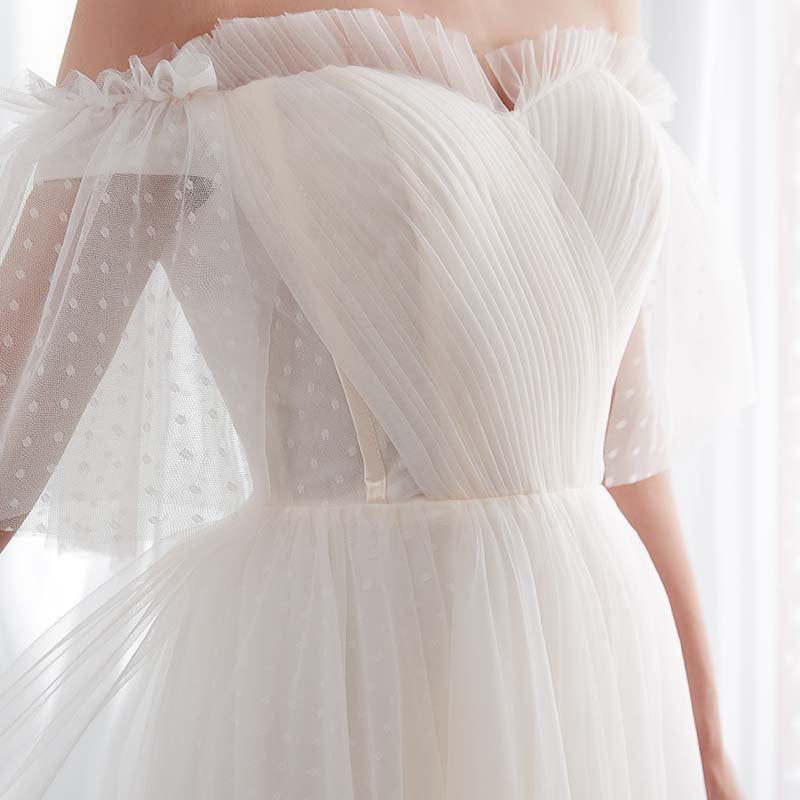 Close-up of a white tulle dress with sheer sleeves on a blurred background