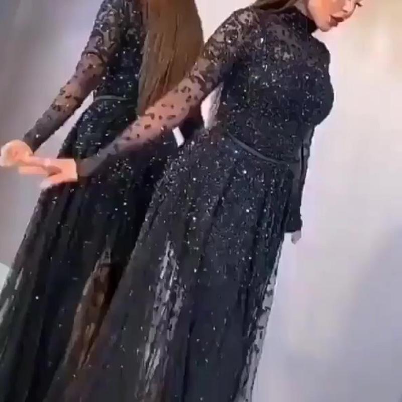 Woman wearing a black sequin dress against a neutral background