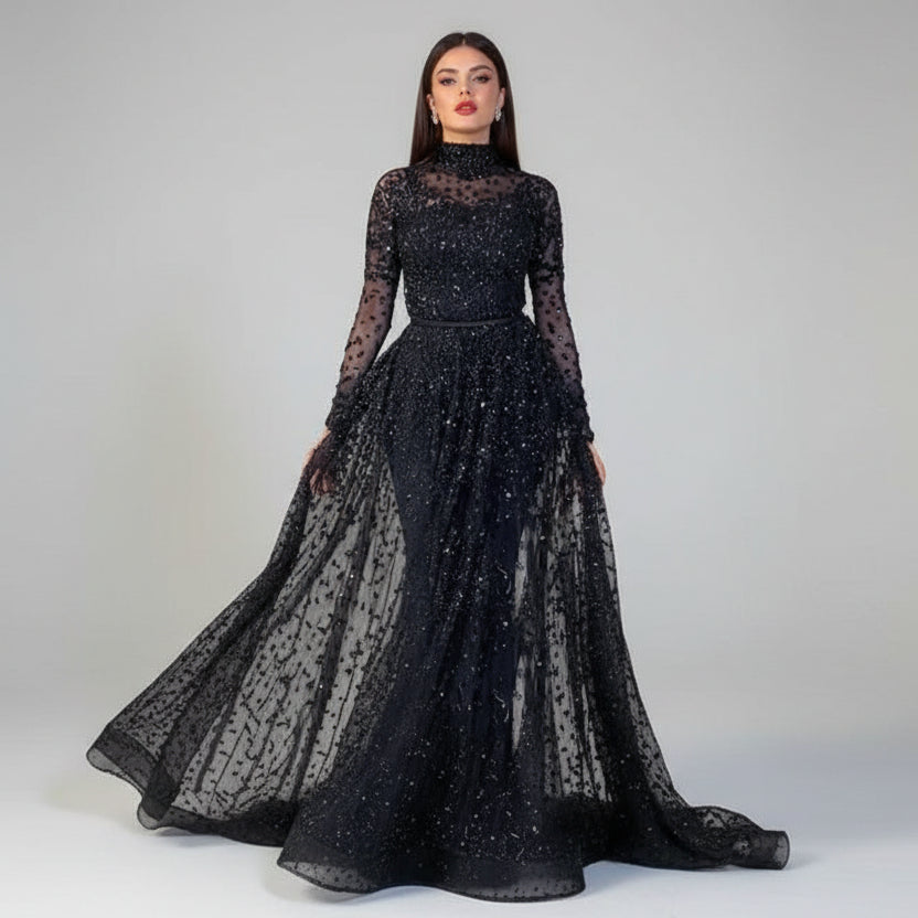 Black sheer evening gown with long sleeves and a flowing skirt on a neutral background