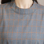 Close-up of a gray and orange checkered fabric on a mannequin