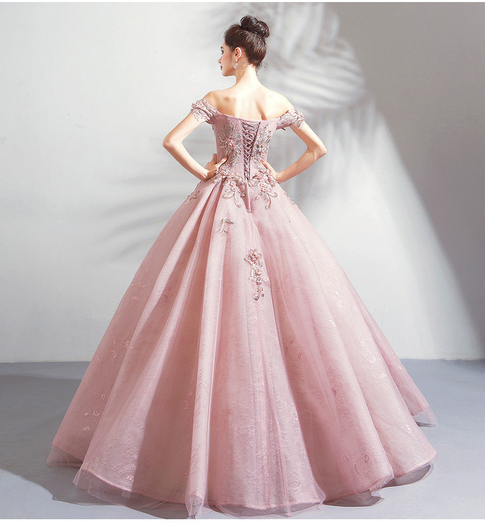 Pink evening gown with floral details on a plain background