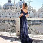 Woman in a blue evening gown standing in front of an ornate building with domes.