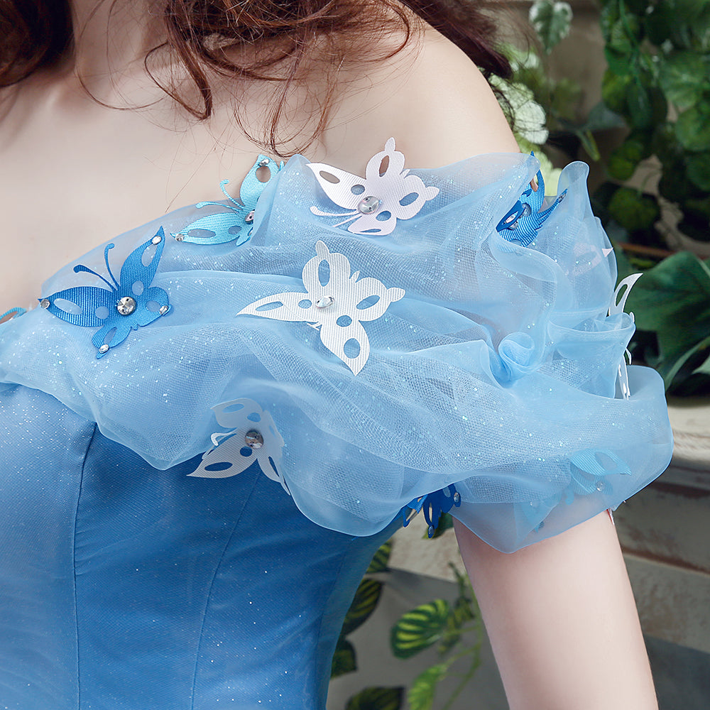Blue dress with butterfly embellishments on a blurred green background