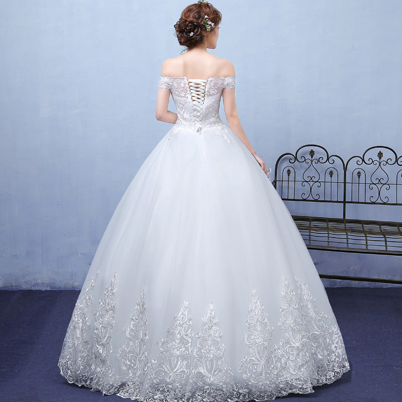 White wedding dress with floral details on a plain background
