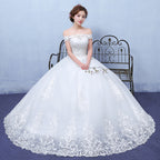 Woman wearing a white wedding dress with lace details in a studio setting.