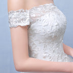 Close-up of a white lace dress with floral patterns on a light blue background