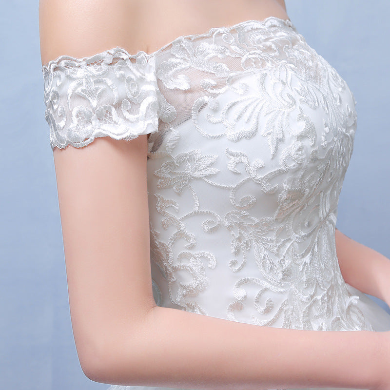 Close-up of a white lace dress with floral patterns on a light blue background