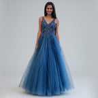 Woman in a blue evening gown standing on steps outside a building