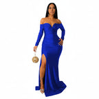 Woman wearing a blue evening gown with a slit, holding a gold clutch against a white background